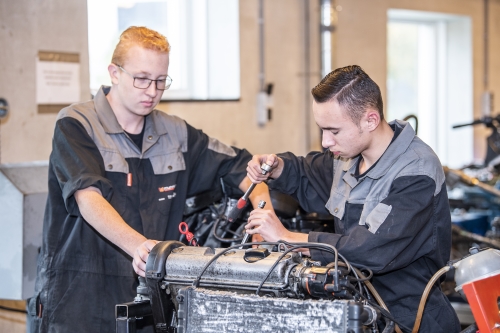 Jongens sleutelen aan motor